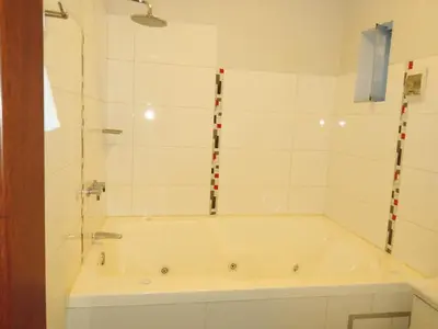 a bath tub in a bathroom with white tiles at Gran Hotel Ica in Ica