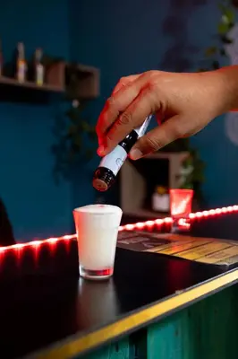 a person is pouring a drink into a cup at The Secret Garden Hostel in Lima