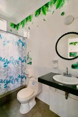 a bathroom with a toilet and a sink at The Secret Garden Hostel in Lima