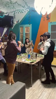 a group of people standing around a table at The Secret Garden Hostel in Lima