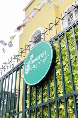 a sign on a fence in front of a building at The Secret Garden Hostel in Lima