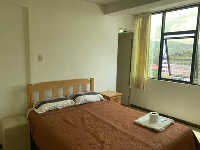 a bedroom with a bed and a window at Rooms MD in Huancayo