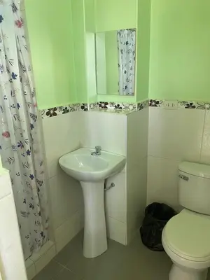 a bathroom with a sink and a toilet and a mirror at Rooms MD in Huancayo