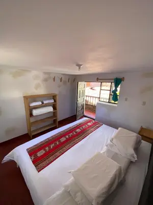 a large white bed in a room with a window at CASA ANDINA PRIVADA a lado del Museo - Qespiwanka in Urubamba