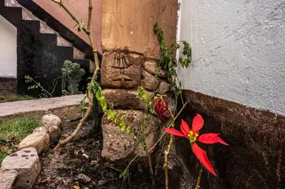 a stone statue with a flower next to a building at CASA ANDINA PRIVADA a lado del Museo - Qespiwanka in Urubamba