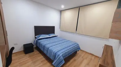a bedroom with a bed with a striped blanket at Departamento exclusivo ica in Ica