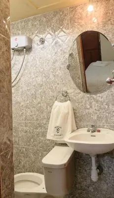 a bathroom with a sink and a toilet and a mirror at Hostal Chasky in Cusco