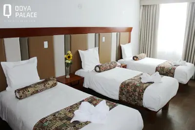 a hotel room with three beds with flowers on them at Hotel Qoya Palace - Machupicchu in Machu Picchu
