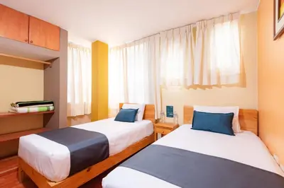 a hotel room with two beds and a window at Hotel Savoy Ica in Ica