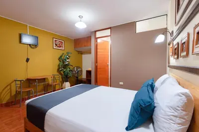 a bedroom with a large bed and a table at Hotel Savoy Ica in Ica