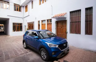 a blue car parked in front of a building at Apartment in the Plaza de Armas Cusco in Cusco