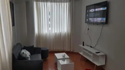 a living room with a couch and a flat screen tv at Hermoso departamento en chorrillos in Lima