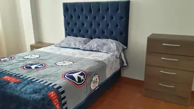 a bedroom with a blue bed with a blue headboard at Hermoso departamento en chorrillos in Lima