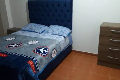 a bedroom with a blue bed with a blue headboard at Hermoso departamento en chorrillos in Lima