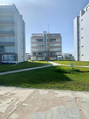 a building with two tall buildings and a grass field at Paracas Paracas! Vista Bahia - Sotavento 201 T 6 in Paracas