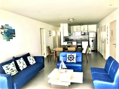 a living room with blue couches and a kitchen at Paracas Paracas! Vista Bahia - Sotavento 201 T 6 in Paracas