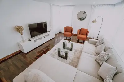 a living room with a white couch and a tv at Departamento Premium De Estreno En Miraflores in Lima