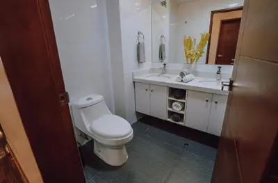 a white bathroom with a toilet and a sink at Departamento Premium De Estreno En Miraflores in Lima