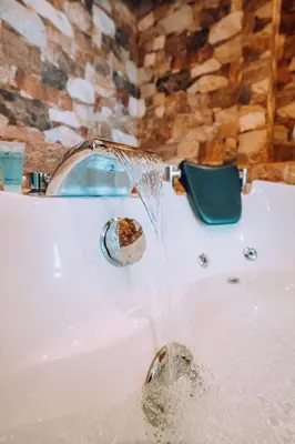 a bath tub with water coming out of a faucet at Lima Central Design Hotel Spa & Club in Lima