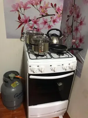 a stove with pots and pans on top of it at 100- departamento céntrico en chorrillos in Lima