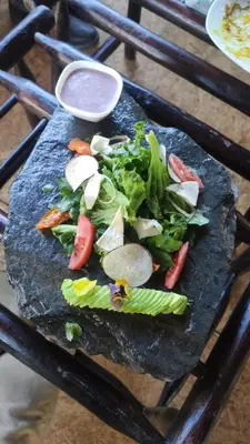 a black board with vegetables and a sauce on it at Vertikal lodge in Santa Teresa
