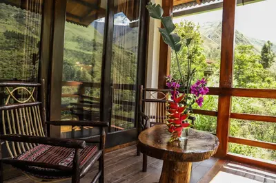a room with two chairs and a table with flowers on it at Vertikal lodge in Santa Teresa