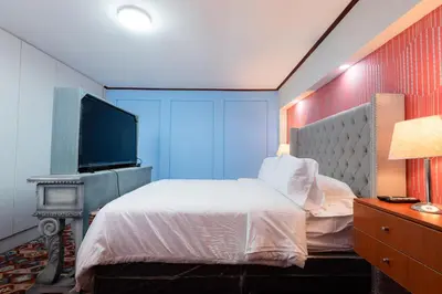 a bedroom with a bed and a flat screen tv at Loft abierto y moderno & Aire acondicionado in Lima