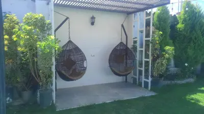 a patio with two hanging hammocks on the side of a house at Villa blanca in Andahuaylas