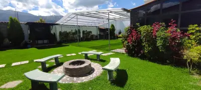 a garden with two benches and a fire pit at Villa blanca in Andahuaylas
