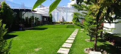 a garden with a green lawn and a building at Villa blanca in Andahuaylas