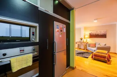 a kitchen with a refrigerator and a living room at Balconcito Peruano & AMPLIO 2 dormitorios in Lima