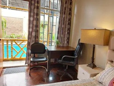 a bedroom with a desk with two chairs and a window at Casa Amarello in Lima