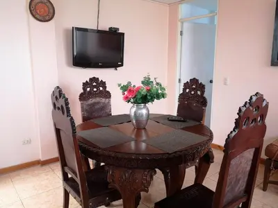a dining room table with a vase of flowers on it at Casa Amarello in Lima