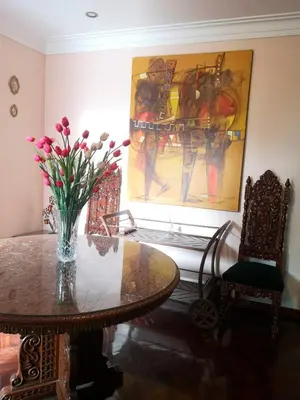a dining room with a table and a vase of flowers at Casa Amarello in Lima