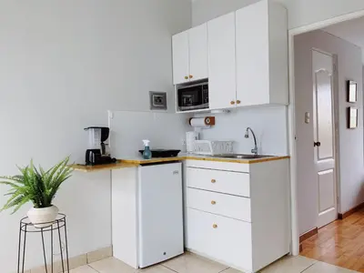 a kitchen with white cabinets and a sink at Parque & Mar lindo alojamiento en San Isidro in Lima