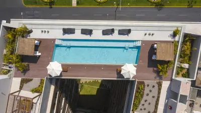 an overhead view of a pool with chairs and umbrellas at ✶ Nazca Penthouse ✶ 3-stories LUXURY Rooftop Pool in Lima