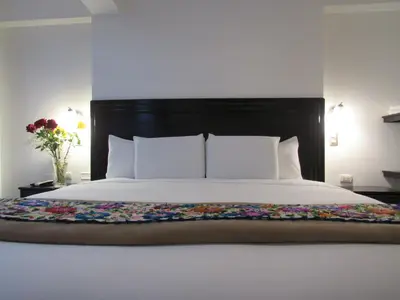 a bed with a black headboard with flowers on it at Quilla House Ecologico in Machu Picchu