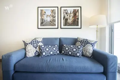 a blue couch with pillows in a living room at Connect by Wynwood House in Lima