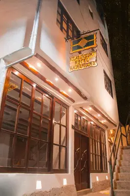 a building with a sign on the side of it at Vilas Insight Hotel Machupicchu in Machu Picchu