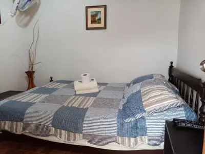 a bed with a blue and white blanket on it at La Casa Maruja Habitación doble P in San Bartolo