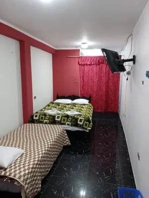two beds in a small room with red walls at La Esquina de Doña Julia in Lima