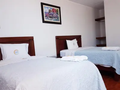 two beds sitting next to each other in a room at Hotel Luz de Luna in Atico