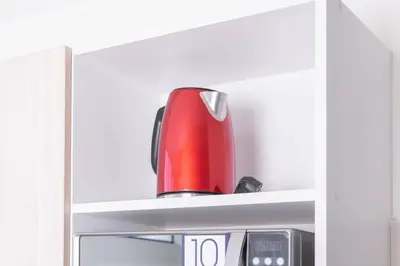 a red kettle sitting on a shelf in a refrigerator at Residencial Suiza in Lima