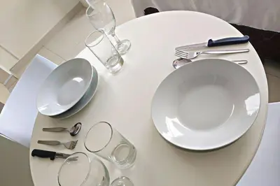 a white table with plates and glasses on it at Residencial Suiza in Lima