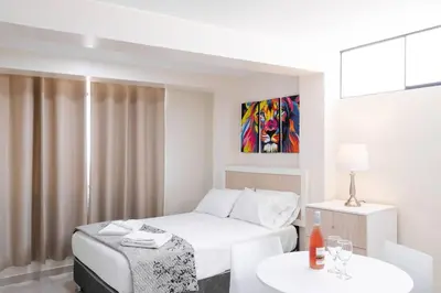 a white room with a bed and a table at Residencial Suiza in Lima