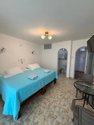 a bedroom with a blue bed and a table at El Gamonal - Paracas in Paracas