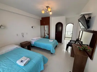a hotel room with two beds and a television at Mar Azul in Paracas
