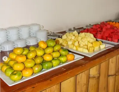 a buffet with apples oranges and other fruits on trays at Hotel Emancipador in Paracas