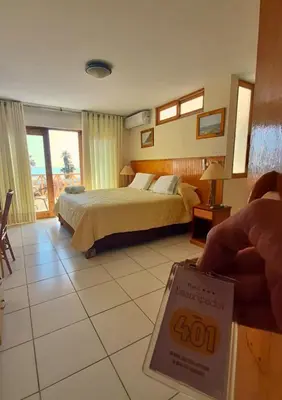 a hotel room with a bed and a sign in the foreground at Hotel Emancipador in Paracas
