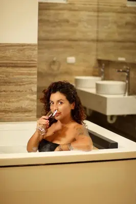 a woman sitting in a bath tub brushing her teeth at Hotel El Condor in Paracas